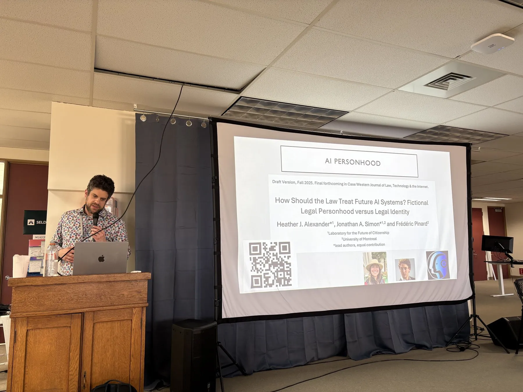 Jonathan Simon at a lectern beside a slide on AI personhood