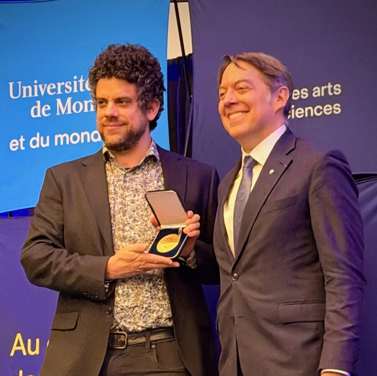Jonathan Simon holding the medal at the ceremony